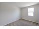 A bright, carpeted bedroom with a window and light colored walls at 24636 W Hopi St, Buckeye, AZ 85326