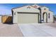 This home features a spacious two-car garage with a long driveway and neutral color scheme at 24636 W Hopi St, Buckeye, AZ 85326