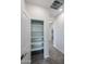 Hallway view of tile floor and storage closet with shelving and light from an adjacent room at 24636 W Hopi St, Buckeye, AZ 85326