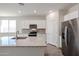 An open-concept kitchen features white cabinets and granite countertops at 24636 W Hopi St, Buckeye, AZ 85326