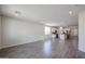 Open living space with gray wood-look tile flooring, and view of a modern kitchen at 24636 W Hopi St, Buckeye, AZ 85326