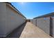 A narrow space between houses, offering potential for a secluded side yard or utility access at 24636 W Hopi St, Buckeye, AZ 85326