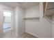 A walk-in closet leads to an ensuite bathroom with carpet and shelving at 24636 W Hopi St, Buckeye, AZ 85326