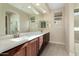 Elegant bathroom with double vanity, large mirror, and a walk-in shower at 26330 W Kimberly Way, Buckeye, AZ 85396