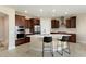 Modern kitchen with curved island, stainless steel appliances, and dark wood cabinets at 26330 W Kimberly Way, Buckeye, AZ 85396