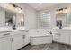 Elegant bathroom with dual vanities, soaking tub, and a subway tile backsplash at 28225 N 65Th Ln, Phoenix, AZ 85083