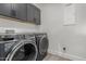 Laundry room with washer, dryer, and dark cabinets at 28225 N 65Th Ln, Phoenix, AZ 85083