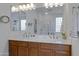 Double vanity bathroom with large mirror and glass block window at 29798 N 121St Dr, Peoria, AZ 85383