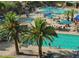 Lively community pool scene with turquoise water, lounge chairs, palm trees, and families enjoying a fun-filled day at 29798 N 121St Dr, Peoria, AZ 85383