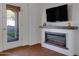 Modern electric fireplace with a dark wood mantel and built-in shelving at 29798 N 121St Dr, Peoria, AZ 85383