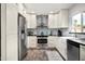 Modern kitchen with white cabinets, patterned backsplash, and stainless steel appliances at 3247 E Silverwood Dr, Phoenix, AZ 85048