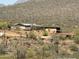 Rustic desert home features a metal roof, multiple buildings, and natural surroundings at 42213 N 3Rd St, Phoenix, AZ 85086