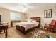 Guest bedroom with wood bed frame and red accent chair at 4547 E Sodalite St, San Tan Valley, AZ 85143