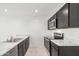 Modern kitchen with dark cabinets, marble countertops, and stainless steel appliances at 5484 E Rock Bush Ln, San Tan Valley, AZ 85140