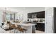 Modern kitchen with island, dark cabinets, and marble countertops; open to living room at 5596 E Arctic Ln, San Tan Valley, AZ 85140