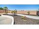 Landscaped backyard with a curved retaining wall at 6618 W Red Fox Rd, Phoenix, AZ 85083