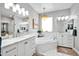 Luxurious bathroom with a soaking tub, marble vanity, and stylish lighting at 6618 W Red Fox Rd, Phoenix, AZ 85083