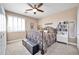 Spacious bedroom with a ceiling fan and large window at 6618 W Red Fox Rd, Phoenix, AZ 85083