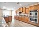 Modern kitchen featuring wood cabinets, stainless steel appliances, and light flooring at 6618 W Red Fox Rd, Phoenix, AZ 85083