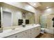 Double vanity bathroom with a large mirror and a walk-in shower at 7105 E Hibiscus Way, Scottsdale, AZ 85266