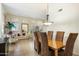 Bright dining area with wood table and brown chairs, adjacent to living room at 7105 E Hibiscus Way, Scottsdale, AZ 85266