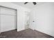 Bedroom with grey carpet, ceiling fan, and built-in shelving at 7213 W Osborn Rd, Phoenix, AZ 85033