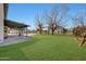 Large grassy backyard with covered patio and trees at 7528 N 185Th Ave, Waddell, AZ 85355