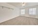 Bright bedroom with carpet flooring, ceiling fan, and two windows at 7528 N 185Th Ave, Waddell, AZ 85355