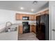 Well-lit kitchen with oak cabinets and black appliances at 910 W Prior Ave, Coolidge, AZ 85128