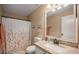 Clean bathroom with granite countertop and floral shower curtain at 9176 N 82Nd Ln, Peoria, AZ 85345