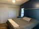 Main bedroom with dark blue accent wall and sliding door closet at 9302 E Broadway Rd # 103, Mesa, AZ 85208