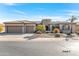 House exterior with a three-car garage and desert landscaping at 20621 N Canyon Whisper Dr, Surprise, AZ 85387
