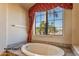 Primary bathroom with an oval soaking tub and a large window at 20621 N Canyon Whisper Dr, Surprise, AZ 85387
