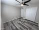 Bedroom with ceiling fan, neutral color scheme, and gray wood floors, closet with mirrored sliding doors at 2629 W Ocotillo Rd # 3, Phoenix, AZ 85017