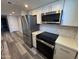 Bright kitchen features stainless appliances, white cabinets, gray wood floors and modern backsplash at 2629 W Ocotillo Rd # 3, Phoenix, AZ 85017