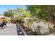 Professionally landscaped backyard with mature trees, garden beds, a stone border, and a dining set at 2705 E Verbena Dr, Phoenix, AZ 85048