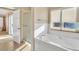 Bright bathroom featuring soaking tub with window, and glass-enclosed shower at 2705 E Verbena Dr, Phoenix, AZ 85048