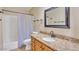 Bathroom vanity with granite countertop, decorative mirror, and shower with curtain at 2705 E Verbena Dr, Phoenix, AZ 85048