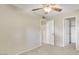 Carpeted bedroom with ceiling fan and a doorway leading to closet with shelving at 2705 E Verbena Dr, Phoenix, AZ 85048