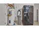 Utility room featuring a water heater, filtration system, and a modern, black refrigerator at 2705 E Verbena Dr, Phoenix, AZ 85048