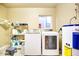 Bright laundry room with washer, dryer, and storage shelves at 2806 N 82Nd St, Scottsdale, AZ 85257