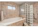 Relaxing bathroom with a soaking tub and a glass block shower enclosure at 36601 N Mule Train Rd # B19, Carefree, AZ 85377