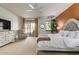 Main bedroom with king bed, access to patio, and ceiling fan at 36601 N Mule Train Rd # B19, Carefree, AZ 85377