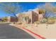 Side view of a two-story home with a two-car garage, showing desert landscaping at 36601 N Mule Train Rd # B19, Carefree, AZ 85377