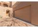 Tan double-door garage with a paved driveway and wrought-iron gate at 36601 N Mule Train Rd # B19, Carefree, AZ 85377
