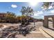 Gated community entrance with paved road and mature trees at 42424 N Gavilan Peak Pkwy # 9206, Anthem, AZ 85086