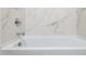 Clean bathroom with a bathtub and marble-look walls at 4930 S 105Th Ln, Tolleson, AZ 85353