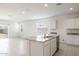 Modern kitchen with white cabinets, granite countertops and island, open to living area at 4930 S 105Th Ln, Tolleson, AZ 85353