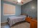 Cozy bedroom with gray bedding, wood flooring, and accent wall at 5330 W Coles Rd, Laveen, AZ 85339