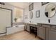 Elegant bathroom with double sinks, a soaking tub, and a walk-in shower at 6216 W Morrow Dr, Glendale, AZ 85308